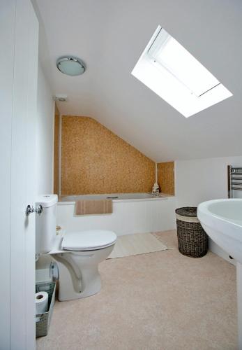 a bathroom with a white toilet and a sink at Finest Retreats - Shortflatt Farm Cottage in Belsay