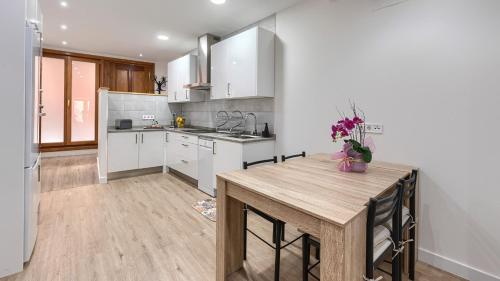 a kitchen with white cabinets and a wooden table at BEHEKO ETXEA in Lekeitio