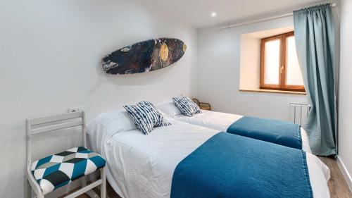 a bedroom with two beds and a window at BEHEKO ETXEA in Lekeitio