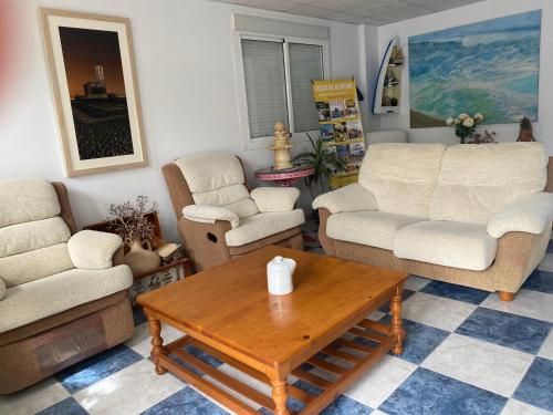 Sala de estar con 2 sofás y mesa de centro en Hostal Puerto Genovés, en San José