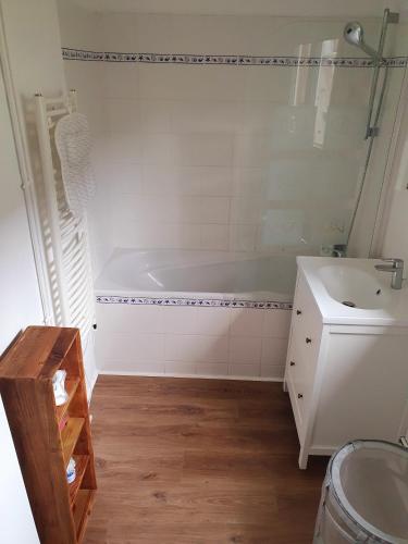 une salle de bain avec une baignoire et un lavabo dans l'établissement Les Ondines Vue Rivière et Mer, à Sainte-Marguerite