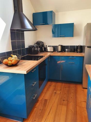 - une cuisine bleue avec des placards bleus et une cuisinière dans l'établissement Les Ondines Vue Rivière et Mer, à Sainte-Marguerite