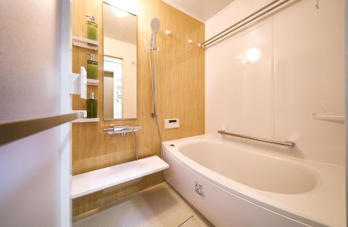a white bathroom with a tub and a sink at Bon in Kyoto