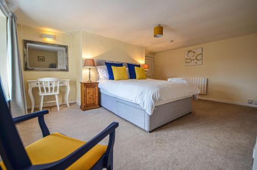 a bedroom with a bed and a chair and a mirror at The Annex at Middle Filham, Ivybridge in Ivybridge