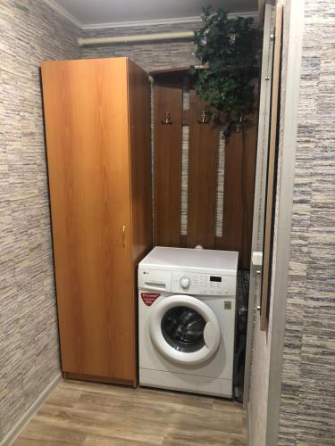 een wasmachine en droger in een kamer met een deur bij Квартира in Saratov