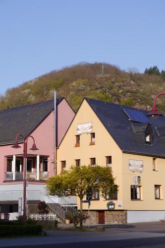 um edifício com uma montanha ao fundo em Cafe Hotel Aroma Moselblick em Burgen