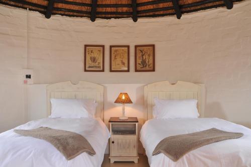 two beds sitting next to each other in a bedroom at De Hoop Collection - Campsite Rondawels in De Hoop Nature Reserve