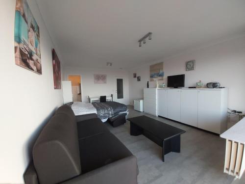 - un salon avec un canapé et un lit dans l'établissement Studio met zeezicht, à Blankenberge