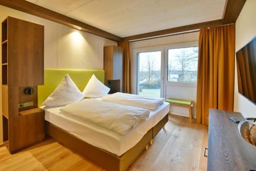 a bedroom with a bed and a large window at Mawell Resort in Langenburg