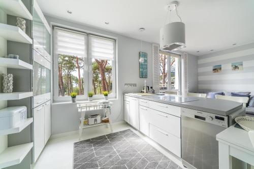 a kitchen with white cabinets and a large window at Blue Bay in Jurata
