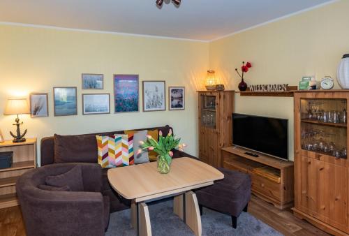 a living room with a couch and a tv at Spreewaldhäuser am See in Alt Schadow
