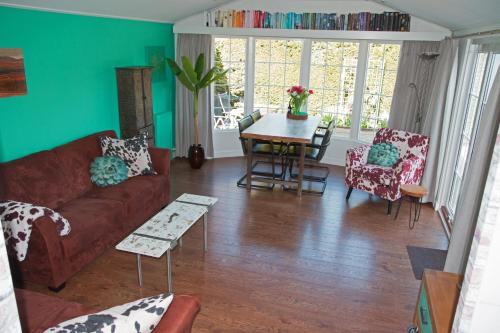 Una sala de estar con un sofá y sillas y una mesa. en dutchduochalet37, en s-Gravenzande