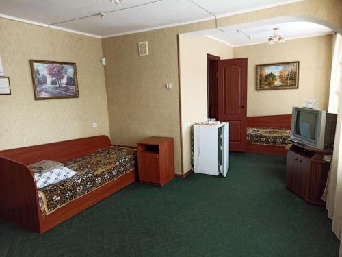 a hotel room with two beds and a tv at Hotel "Nizhyn" in Nizhyn