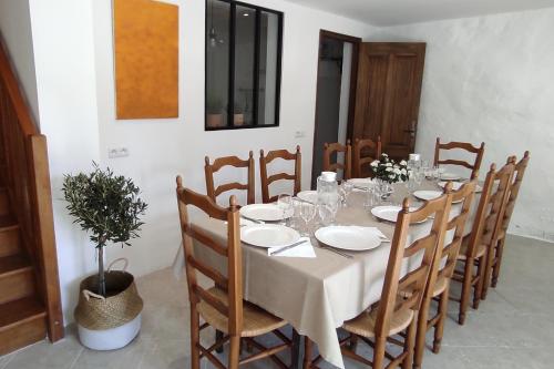 - une table à manger avec un chiffon blanc et des chaises en bois dans l'établissement Mas d'Alauré, à Verquières