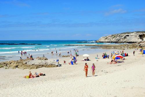 a group of people on a beach near the ocean at Arniston Cottage in Arniston