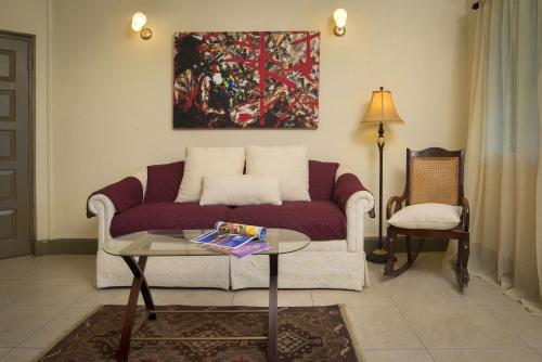 a living room with a couch and a table at Ground floor apartment located in Hometown, 5 min walk to the Beach in Saint James