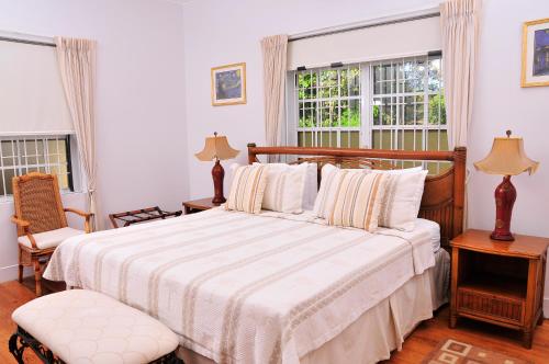 a bedroom with a bed and two windows at Seagaze beach house is perfect for family, a few steps to the beach in Saint James