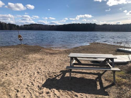 a picnic table on the shore of a lake at Paradiset stugan i fin skogen in Hällefors