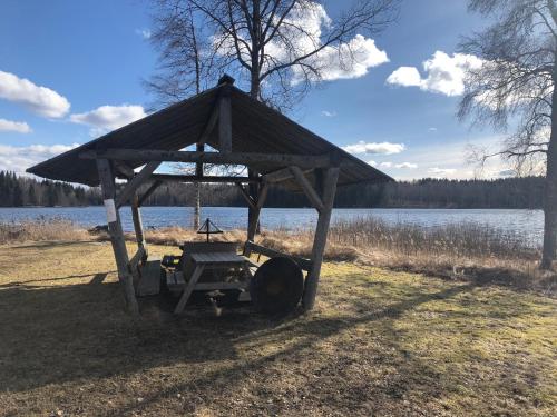 a wooden structure sitting on the side of a lake at Paradiset stugan i fin skogen in Hällefors