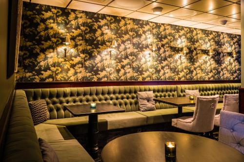 a restaurant with a couch and tables and a floral wall at Hotel Kea by Keahotels in Akureyri