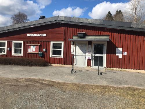 a red building with a sign on the side of it at Paradiset stugan i fin skogen in Hällefors