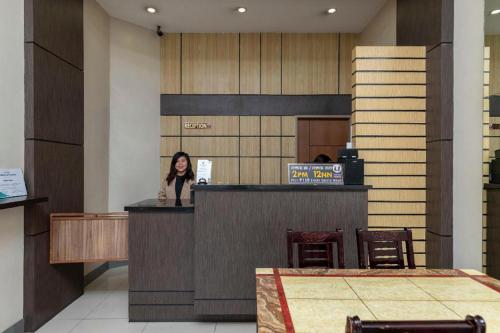 a woman standing at a counter in a lobby at OYO 767 Hotel Urban - Khotel Kurban Hotel in Baguio