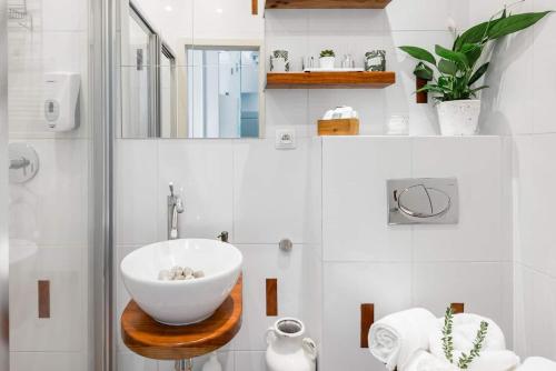 a bathroom with a white bowl sink on a wooden table at Old Town Square Apartment in Prague