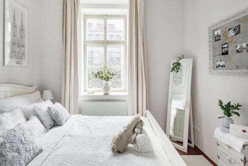 a white bedroom with a large bed and a window at Old Town Square Apartment in Prague