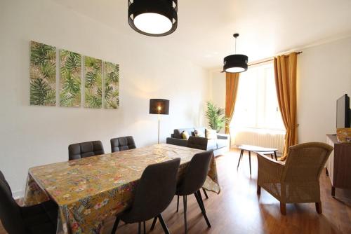 a living room with a dining room table and chairs at Appartements Le Cru Colbert in Beaune