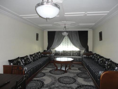 a living room with couches and a table and a window at Appart Hotel Star in Tangier