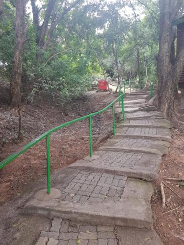 a set of stone steps with a green rail at ATKV Klein-Kariba in Bela-Bela
