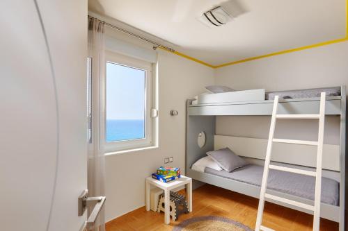 a bedroom with two bunk beds and a window at Breathtaking sea view flat for families in Crete in Keratokampos