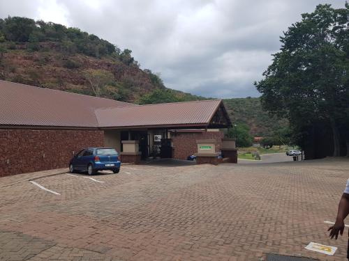 a building with a car parked in a parking lot at ATKV Klein-Kariba in Bela-Bela
