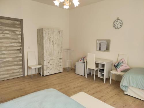 a bedroom with a bed and a desk and a bed and a table at Cerva Bianca B&B in Santa Maria Capua Vetere