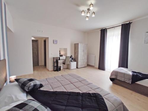 a bedroom with two beds and a desk in it at Cerva Bianca B&B in Santa Maria Capua Vetere