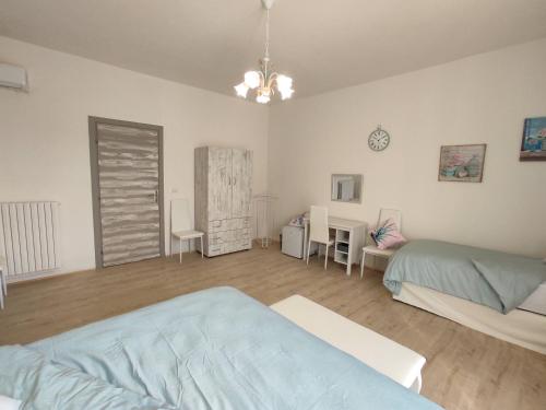 a bedroom with two beds and a table and chairs at Cerva Bianca B&B in Santa Maria Capua Vetere