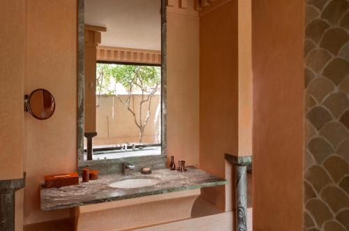 a bathroom with a sink and a large mirror at Amanjena Resort in Marrakech