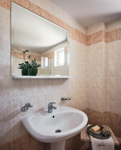 a bathroom with a sink and a mirror at Nemesis Aparthotel in Laganas