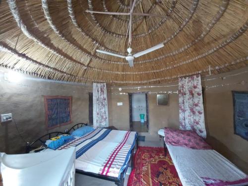 a bedroom with a bed and a ceiling with a fan at Vamoose Shri Ram Wild Desert Resort in Bikaner