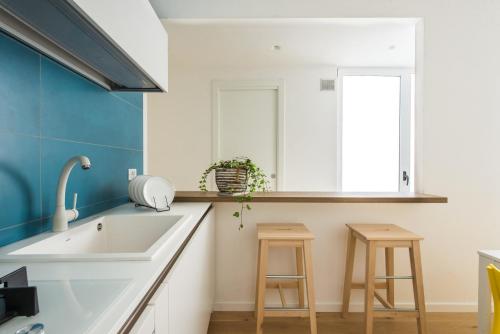 切法盧的住宿－Matteotti 16 - Suites in Cefalù，厨房配有水槽和2张凳子