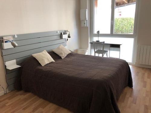 une chambre avec un grand lit avec une grande tête de lit dans l'établissement Appart'Hotel Wombat and Wallaby, à Fussy