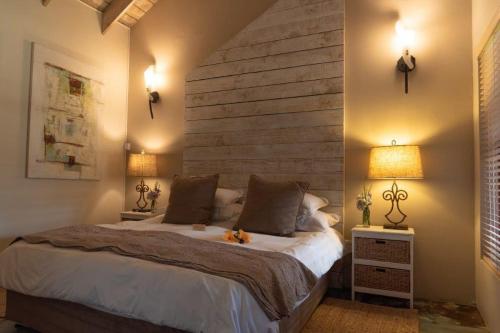 a bedroom with a large bed and two lamps at Villa Chad Luxury Guesthouse in Kleinmond