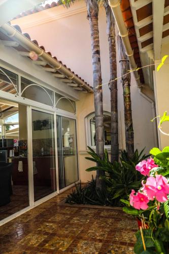 a lobby with palm trees and pink flowers at B&B Val D'azur in Carqueiranne