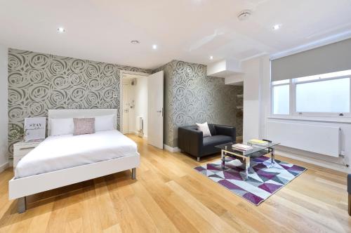 ロンドンにあるRed Lion Court by City2Stayのベッドルーム1室(ベッド1台、椅子、テーブル付)