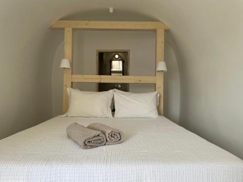 a bed with two towels on top of it at Cosmoia Cave House in Oia