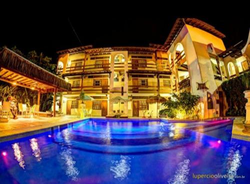 une piscine devant un immeuble la nuit dans l'établissement Pousada Pier do Pontal, à Ilhéus
