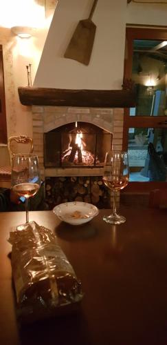 uma mesa com dois copos de vinho e uma lareira em Agriturismo La Mandragola Relais em Crotone