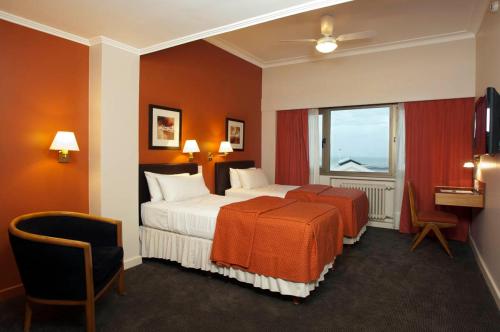 Habitación de hotel con cama y ventana en Austral Express en Comodoro Rivadavia