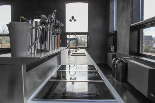 a kitchen with a sink and a counter top at La Classe - Former school of the village of Denée in Denée