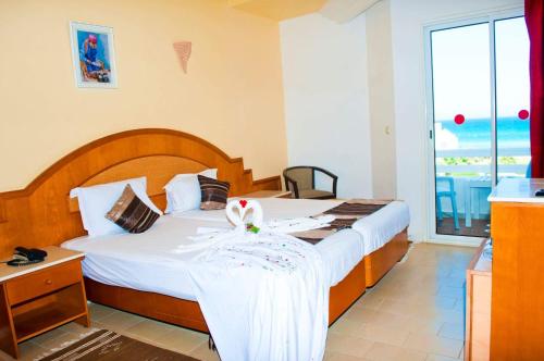 a hotel room with a bed and a large window at Thapsus Beach Resort in Mahdia
